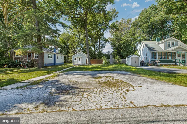 a view of a house with a big yard and large trees