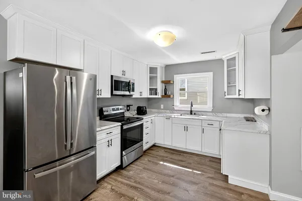 a kitchen with stainless steel appliances a refrigerator stove microwave and sink