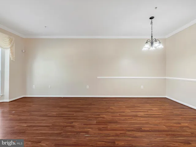 a view of a room with wooden floor and white walls