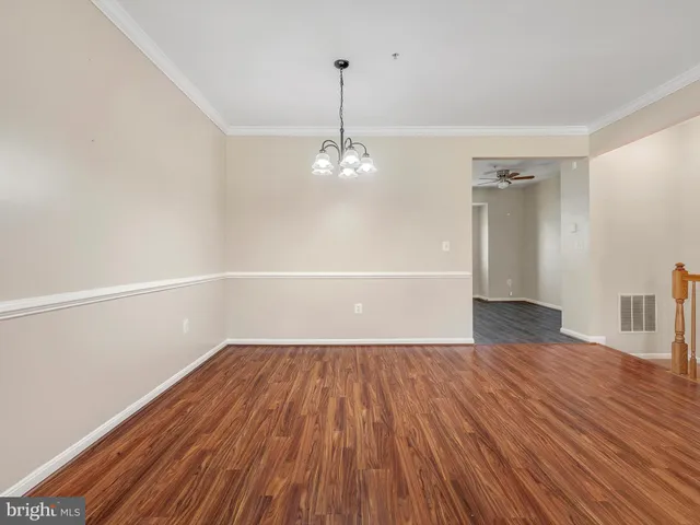 a view of a room with wooden floors and white walls
