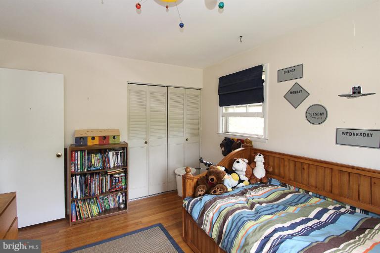 15313 Good Hope Road Silver Spring, MD 20905 - Photo 8 of 10 a bed room with a bed and a book shelf