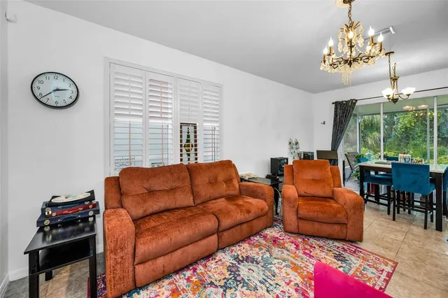 a living room with furniture a chandelier and a window