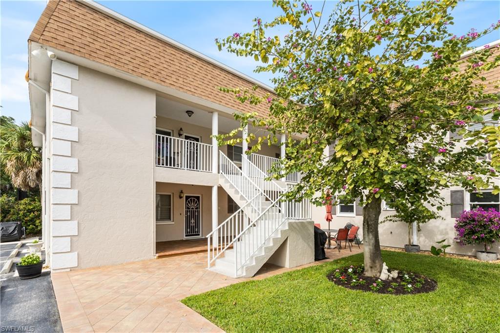 a front view of a house with a garden and trees