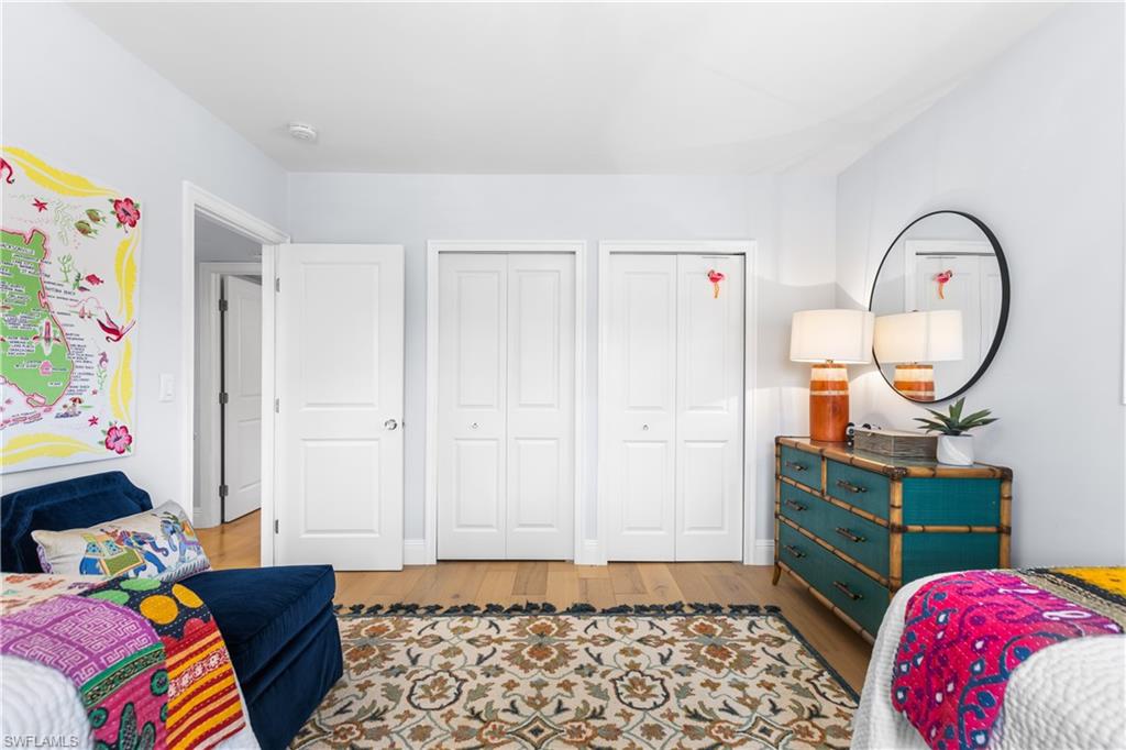 940 3rd Street South, Unit 201 Naples, FL 34102 - Photo 15 of 27 a bedroom with a bed and a chandelier