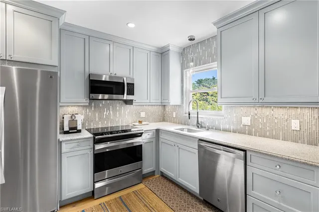 a kitchen with a sink stove and microwave