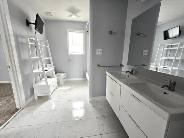 a spacious bathroom with a double vanity sink a mirror and a bathtub