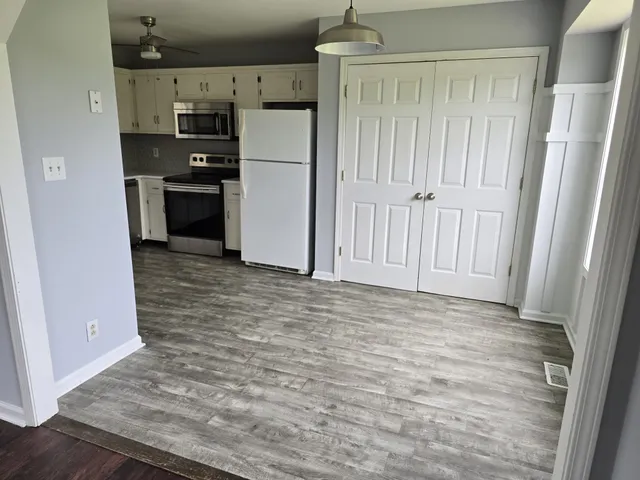 a view of a refrigerator in kitchen and wooden floor