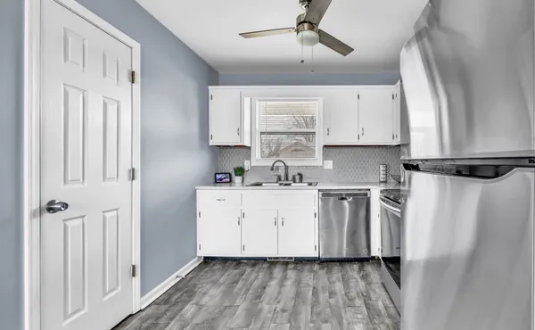 a kitchen with stainless steel appliances white cabinets and a window