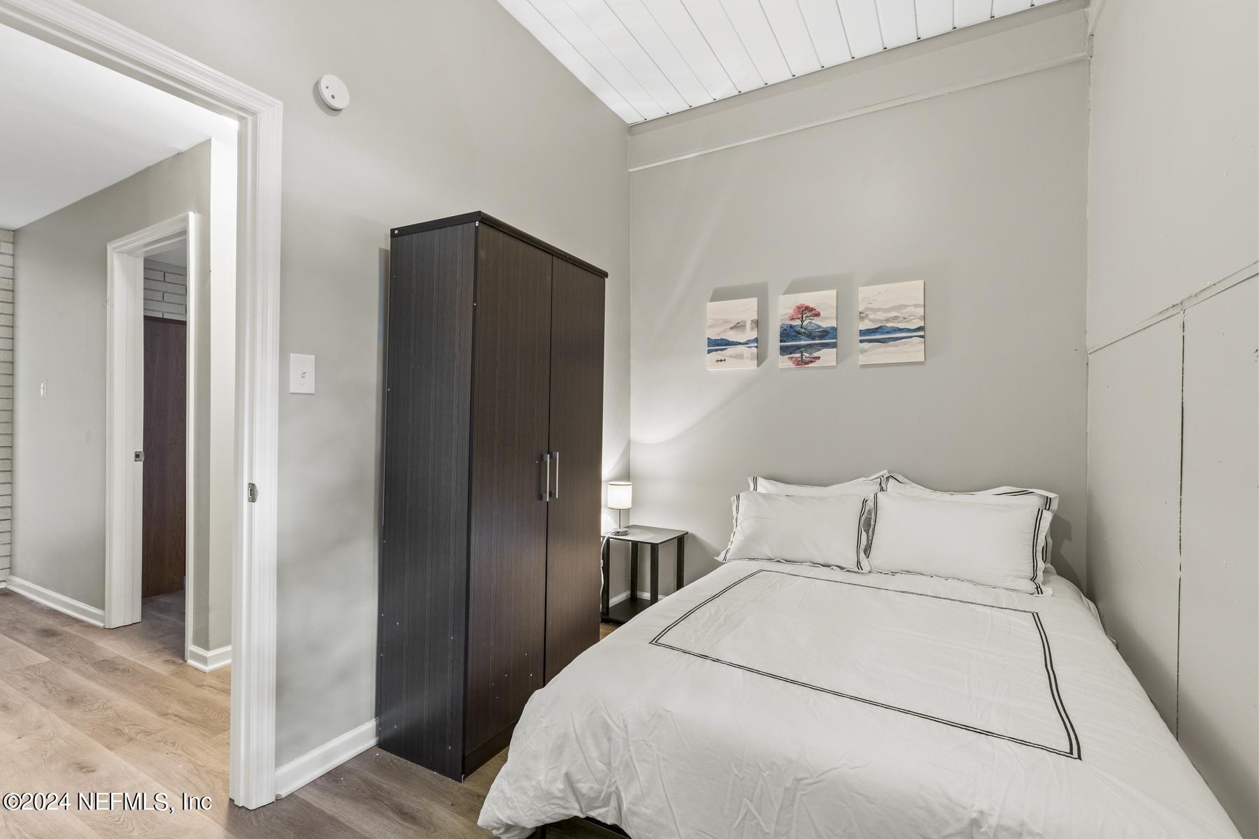 7142 Richardson Road Jacksonville, FL 32209 - Photo 3 of 10 a bedroom with a bed and a painting on the wall