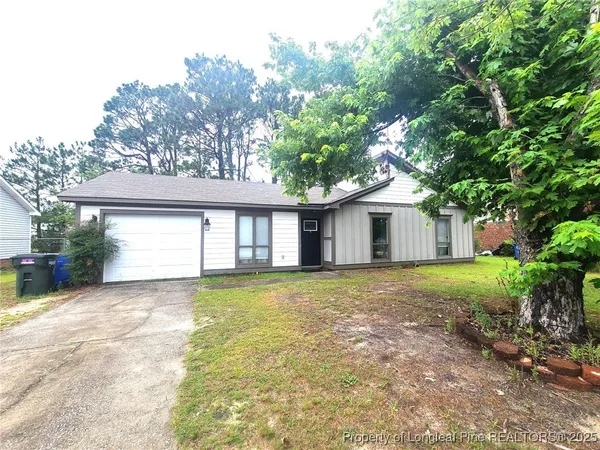a front view of a house with a yard and trees