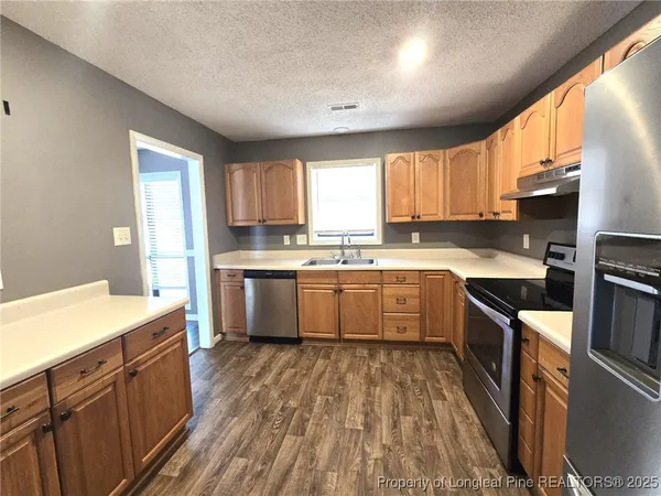 a kitchen with a sink stove top oven and cabinets