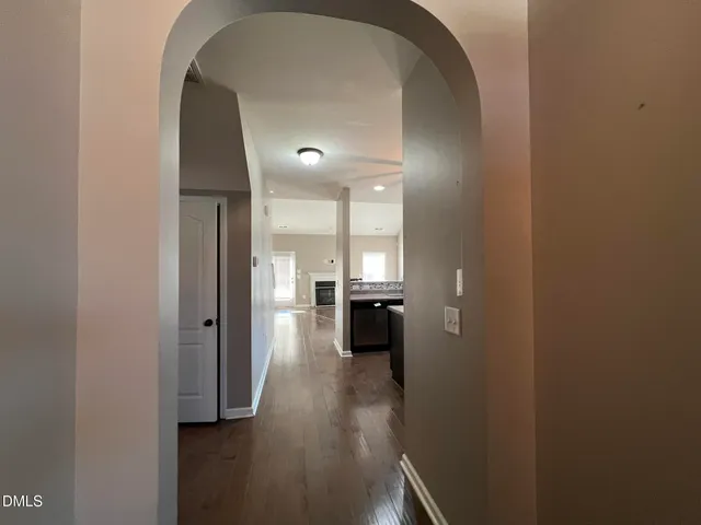 a view of a hallway with wooden floor furniture and a living room