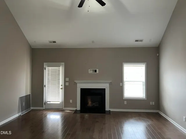 wooden floor fireplace and window in an empty room
