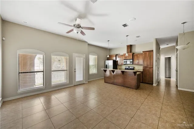 a large kitchen with stainless steel appliances granite countertop a stove a refrigerator a sink dishwasher with a dining table and chairs