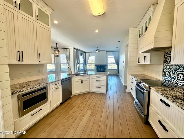a large kitchen with stainless steel appliances granite countertop a stove oven and a refrigerator