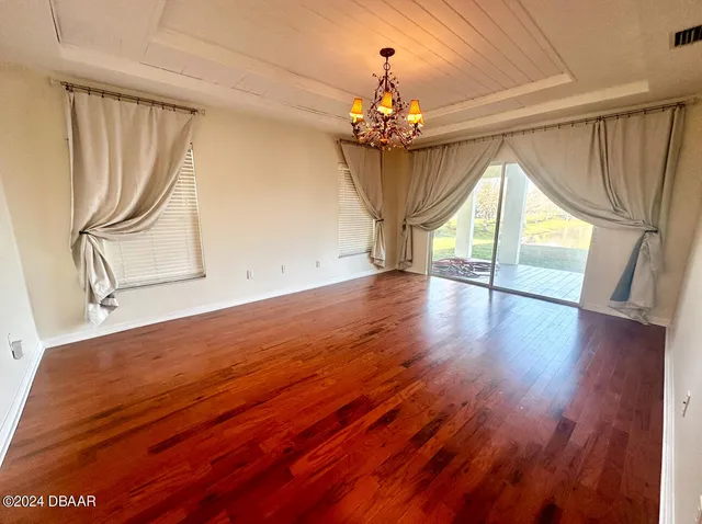 a view of a room with wooden floors and chandelier