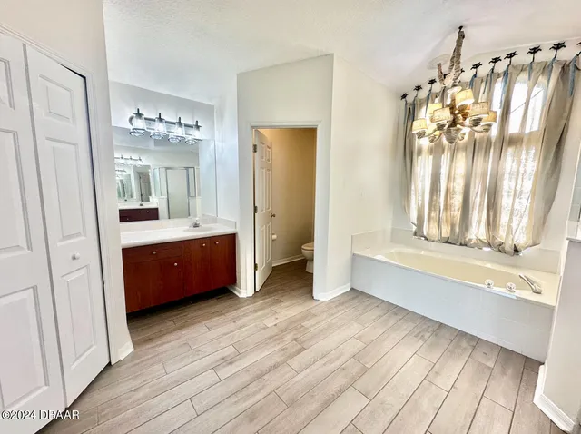 a spacious bathroom with a tub sink and mirror