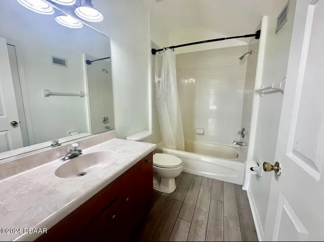 a bathroom with a sink a toilet a large mirror and shower