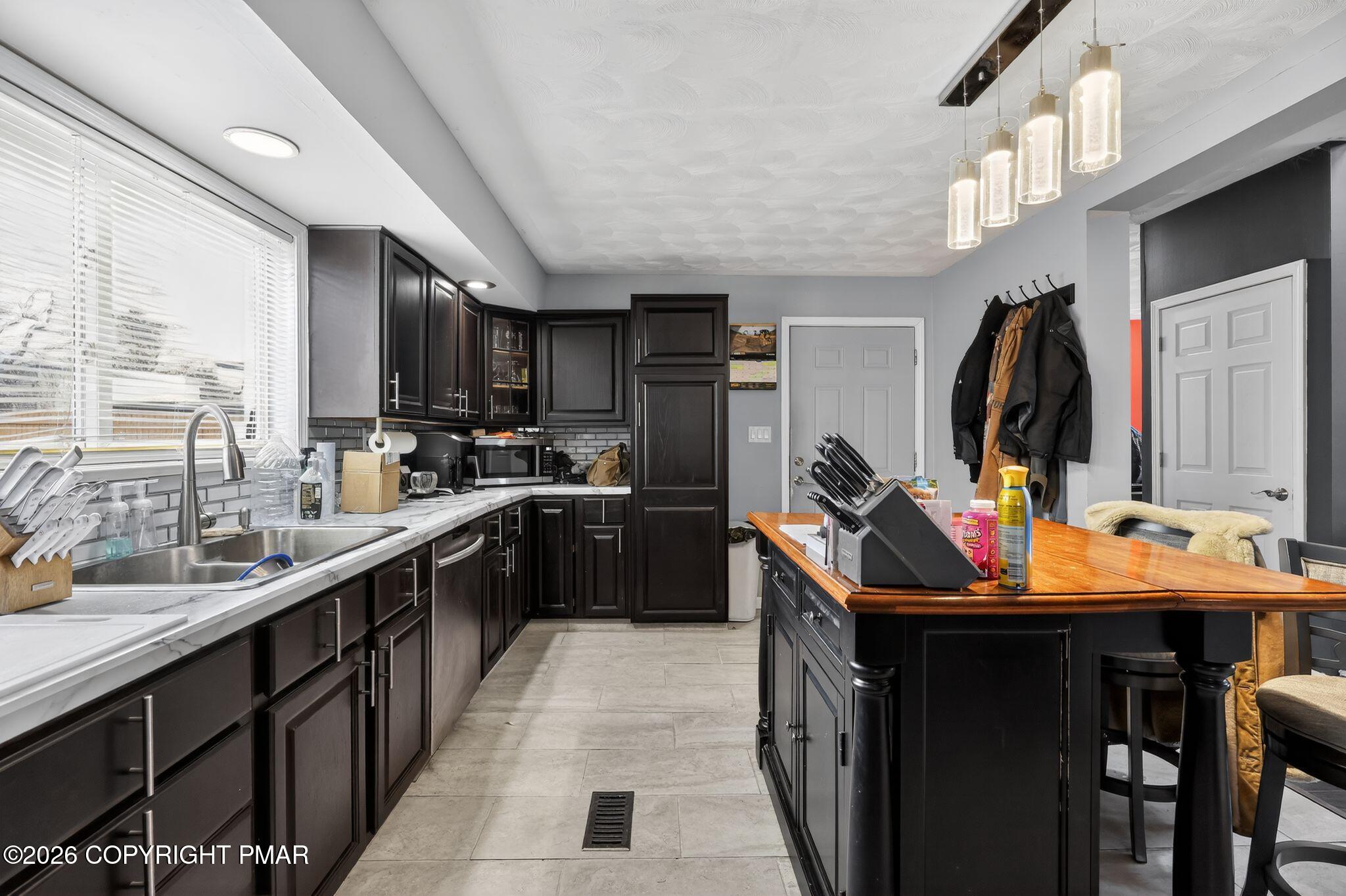 411 Moosic Road Old Forge, PA 18518 - Photo 23 of 59 a kitchen with stainless steel appliances a sink stove refrigerator and cabinets