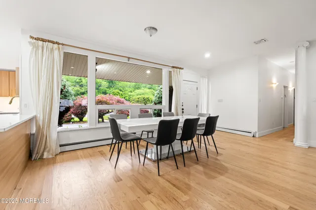 a dining room with furniture window and wooden floor