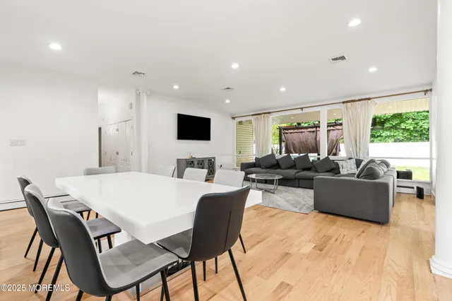 a living room with furniture a flat screen tv and a large window