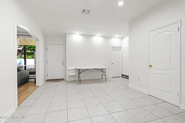 a large white kitchen with stainless steel appliances kitchen island granite countertop a large counter top and a view of living room