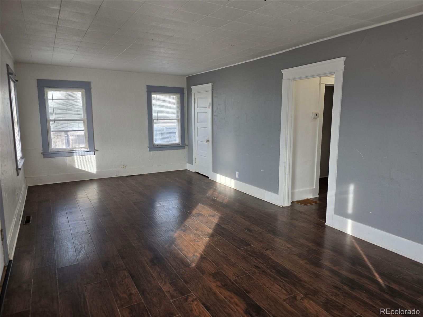 314 7th Street Ovid, CO 80744 - Photo 4 of 17 an empty room with wooden floor and windows