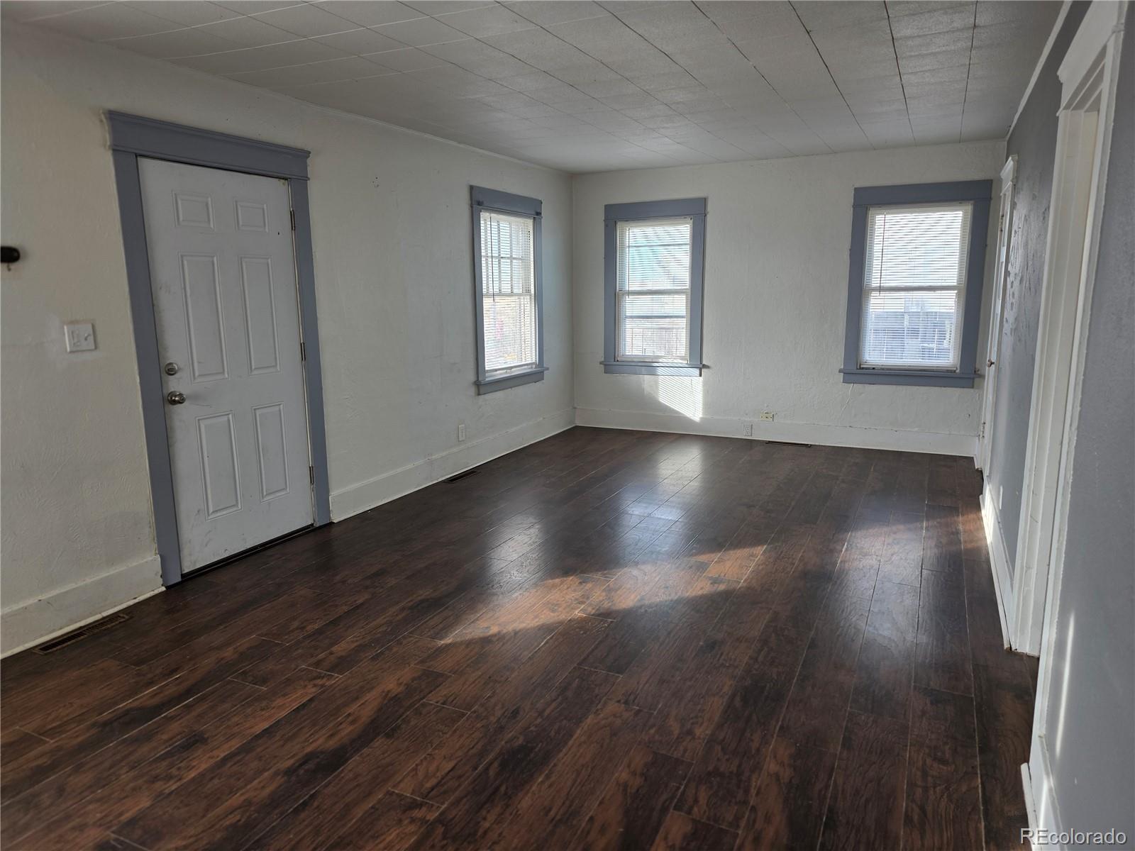 314 7th Street Ovid, CO 80744 - Photo 6 of 17 a view of an empty room with wooden floor and a window