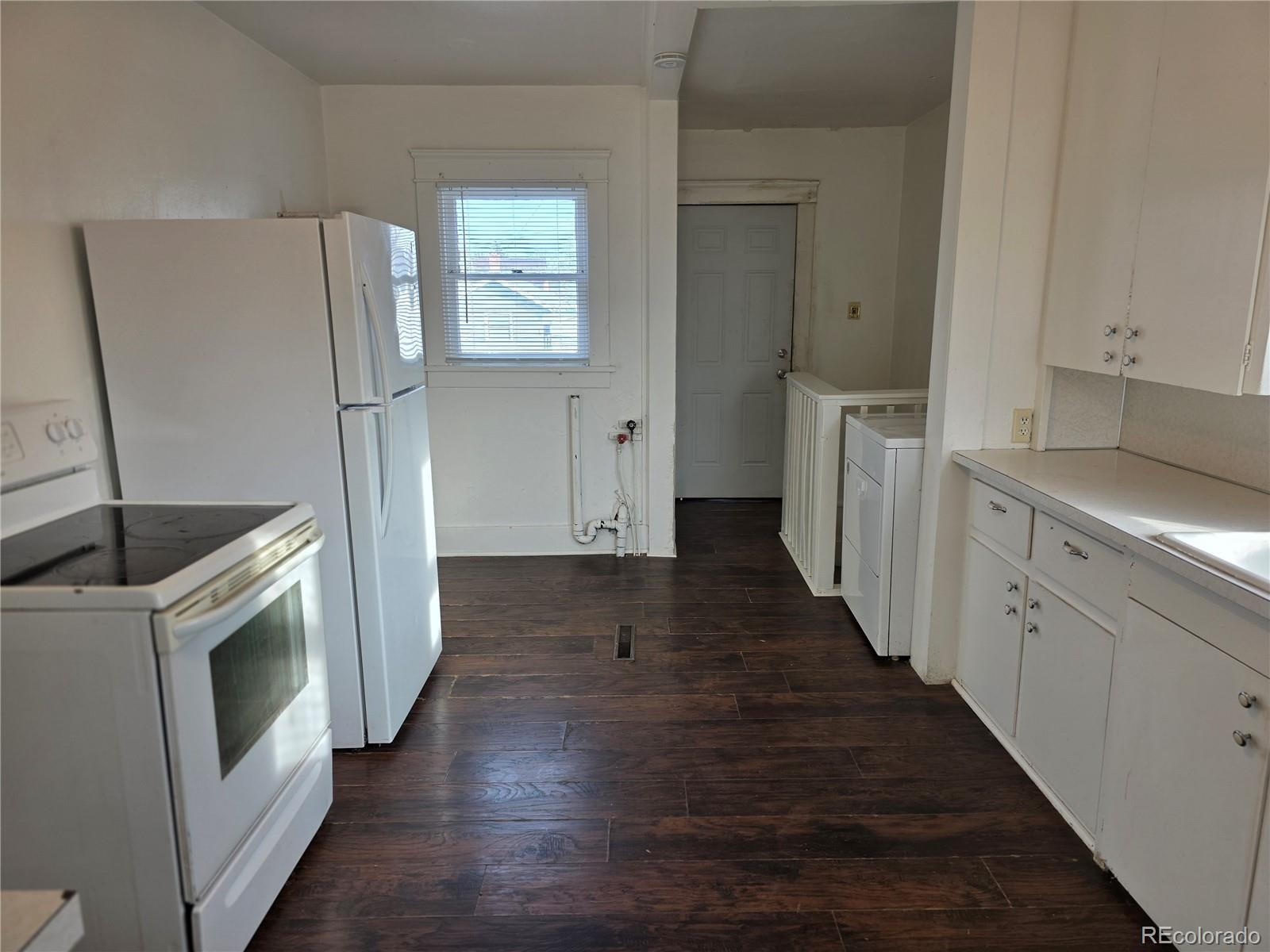 314 7th Street Ovid, CO 80744 - Photo 7 of 17 a kitchen with cabinets and wooden floor
