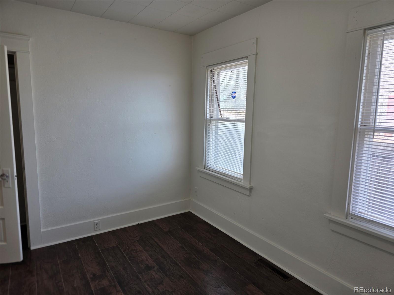 314 7th Street Ovid, CO 80744 - Photo 10 of 17 an empty room with wooden floor and windows