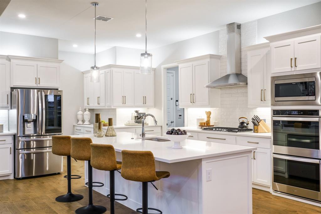 892 Panorama Drive Allen, TX 75013 - Photo 17 of 40 a kitchen with stainless steel appliances a stove a sink a refrigerator and chairs