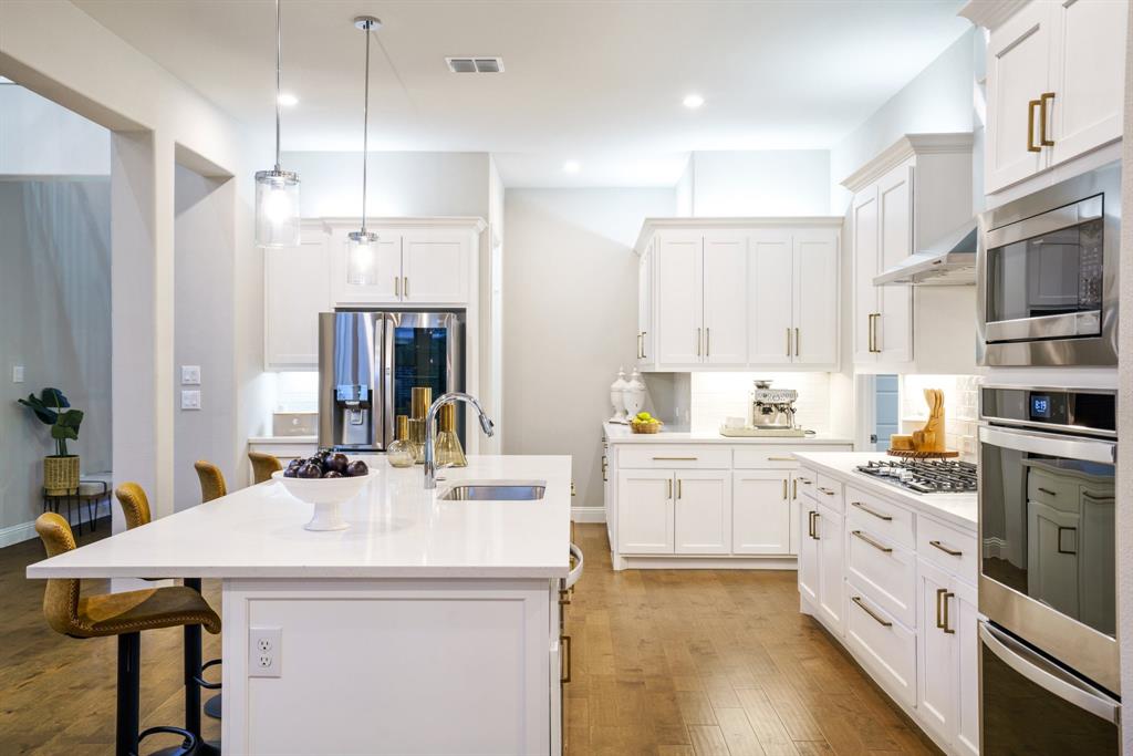 892 Panorama Drive Allen, TX 75013 - Photo 18 of 40 a kitchen with stainless steel appliances kitchen island granite countertop a sink and cabinets