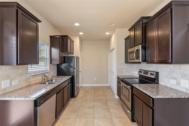 a kitchen with granite countertop stainless steel appliances and sink