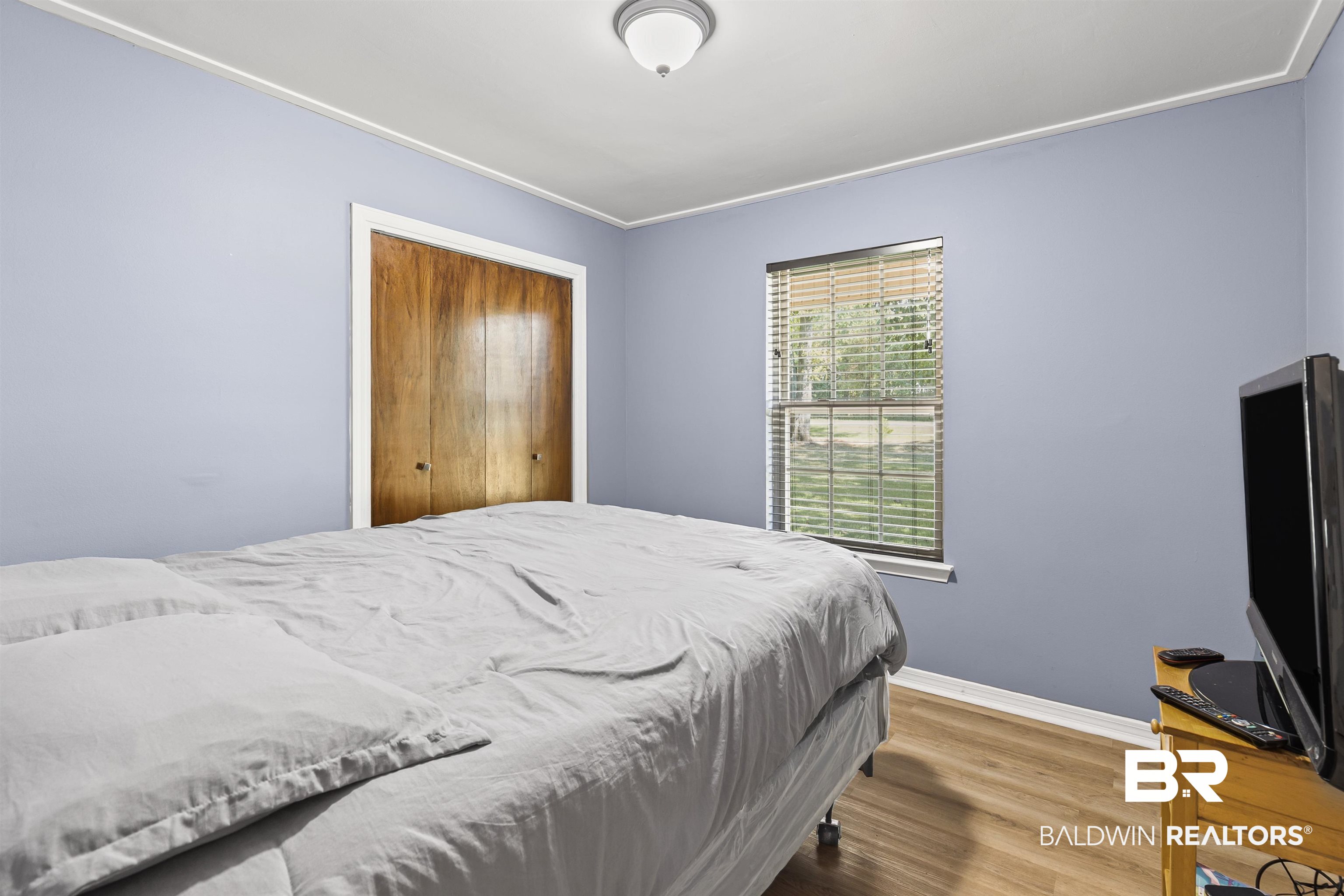 8911 Owassa Road Evergreen, AL 36401 - Photo 15 of 24 Bedroom featuring wood finished floors, a closet, and crown molding