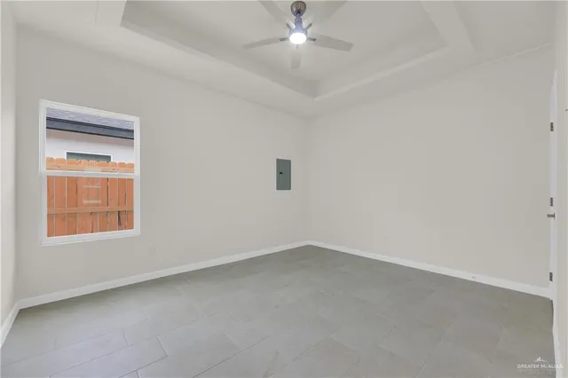 an empty room with a window and a fan