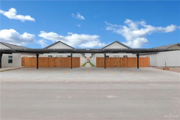 a view of yellow house with a yard and large tree