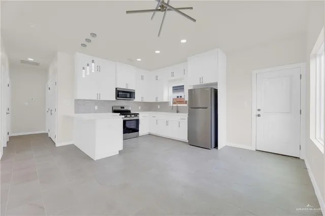a view of a kitchen with refrigerator and a stove top oven