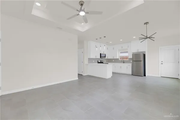a view of a kitchen with a sink and a refrigerator