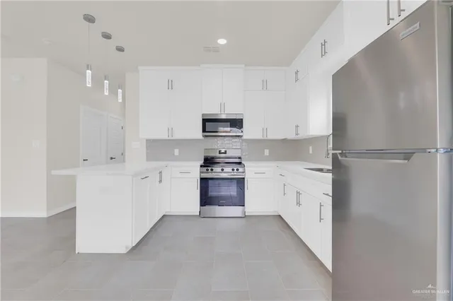 a kitchen with granite countertop white cabinets and refrigerator