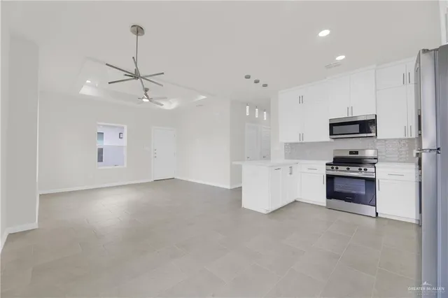 a kitchen with stainless steel appliances a refrigerator sink and stove top oven