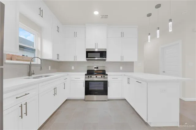 a kitchen with granite countertop white cabinets and stainless steel appliances