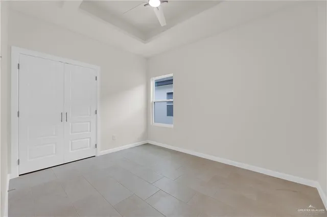 a view of an empty room and chandelier fan
