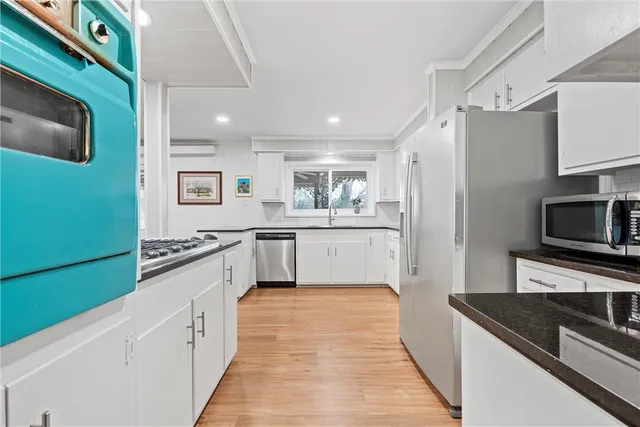 a kitchen with stainless steel appliances granite countertop wooden cabinets and sink