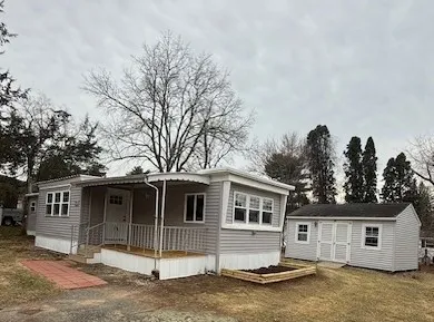 a view of a house with a yard and large tree