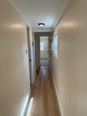 a view of a hallway with wooden floor