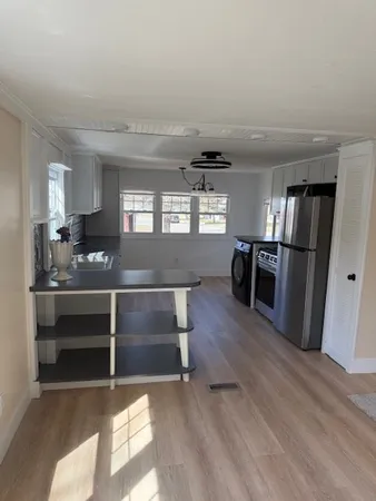 a kitchen with stainless steel appliances granite countertop a refrigerator and a stove top oven