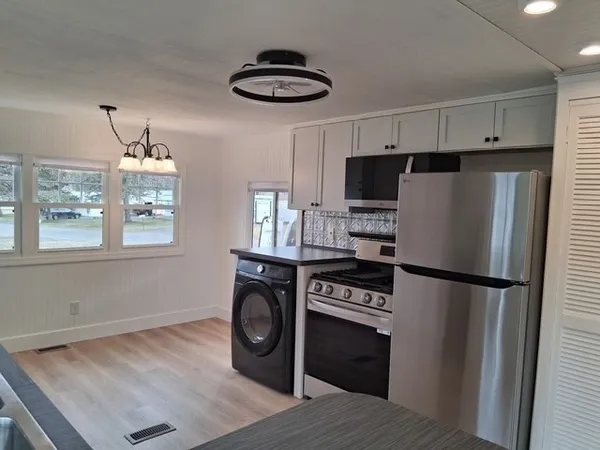 a kitchen with stainless steel appliances a refrigerator a stove a microwave and cabinets