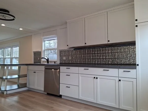 a kitchen with granite countertop white cabinets and sink