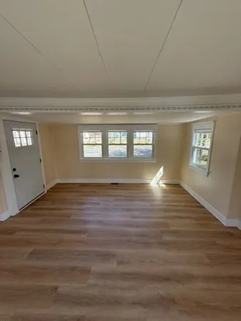 a view of empty room with window and wooden floor