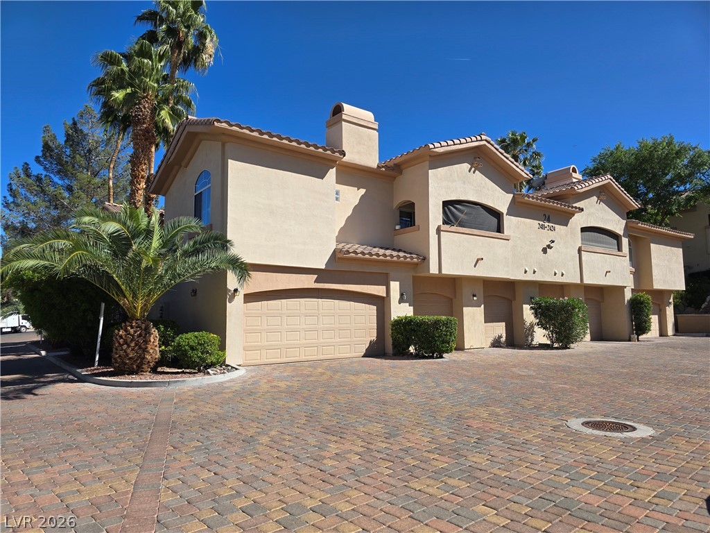 2050 West Warm Springs Road, Unit 2422 Henderson, NV 89014 - Photo 3 of 44 This captivating exterior showcases classic stucco finishes, arched windows, and a paver driveway.